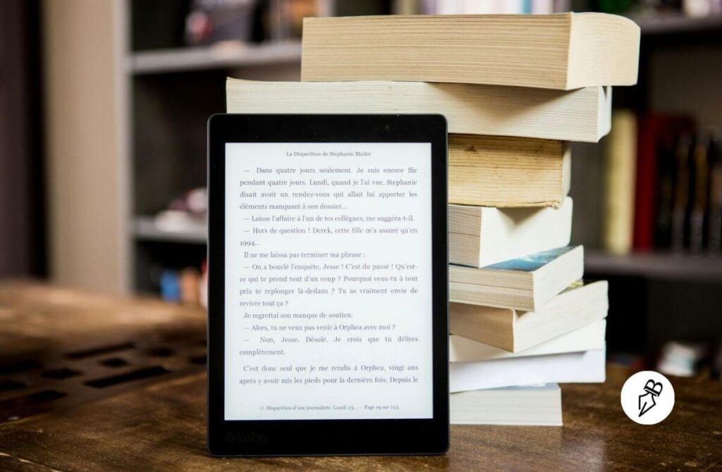 Liseuse posée contre une pile de livres papiers